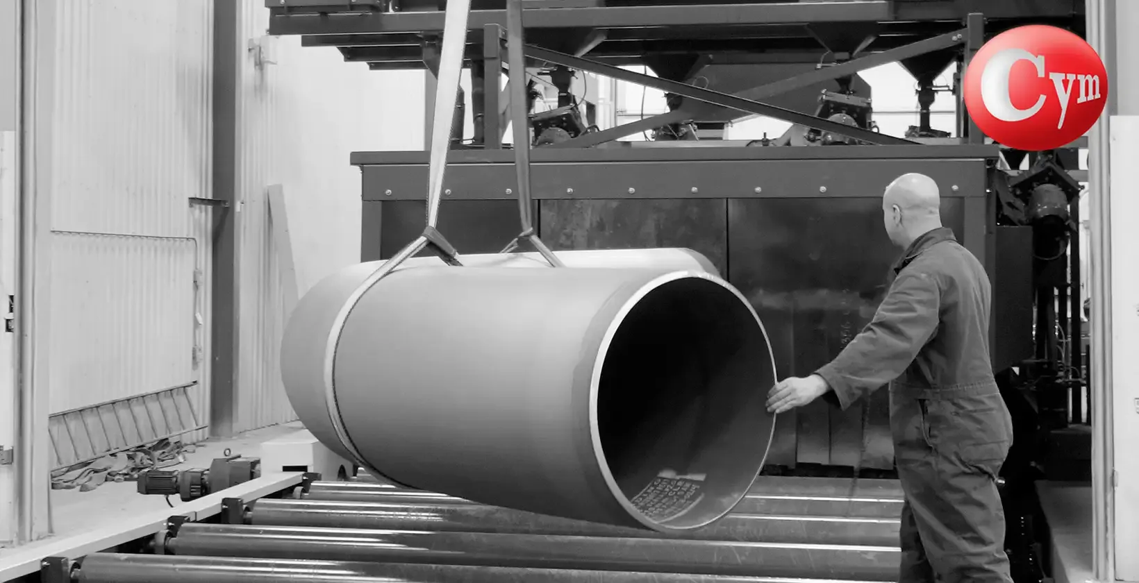 Granalhadora CYM EST-ROD 35x17 – operário descarregando tubo curvado (bending pipe) de grande diâmetro após o jateamento