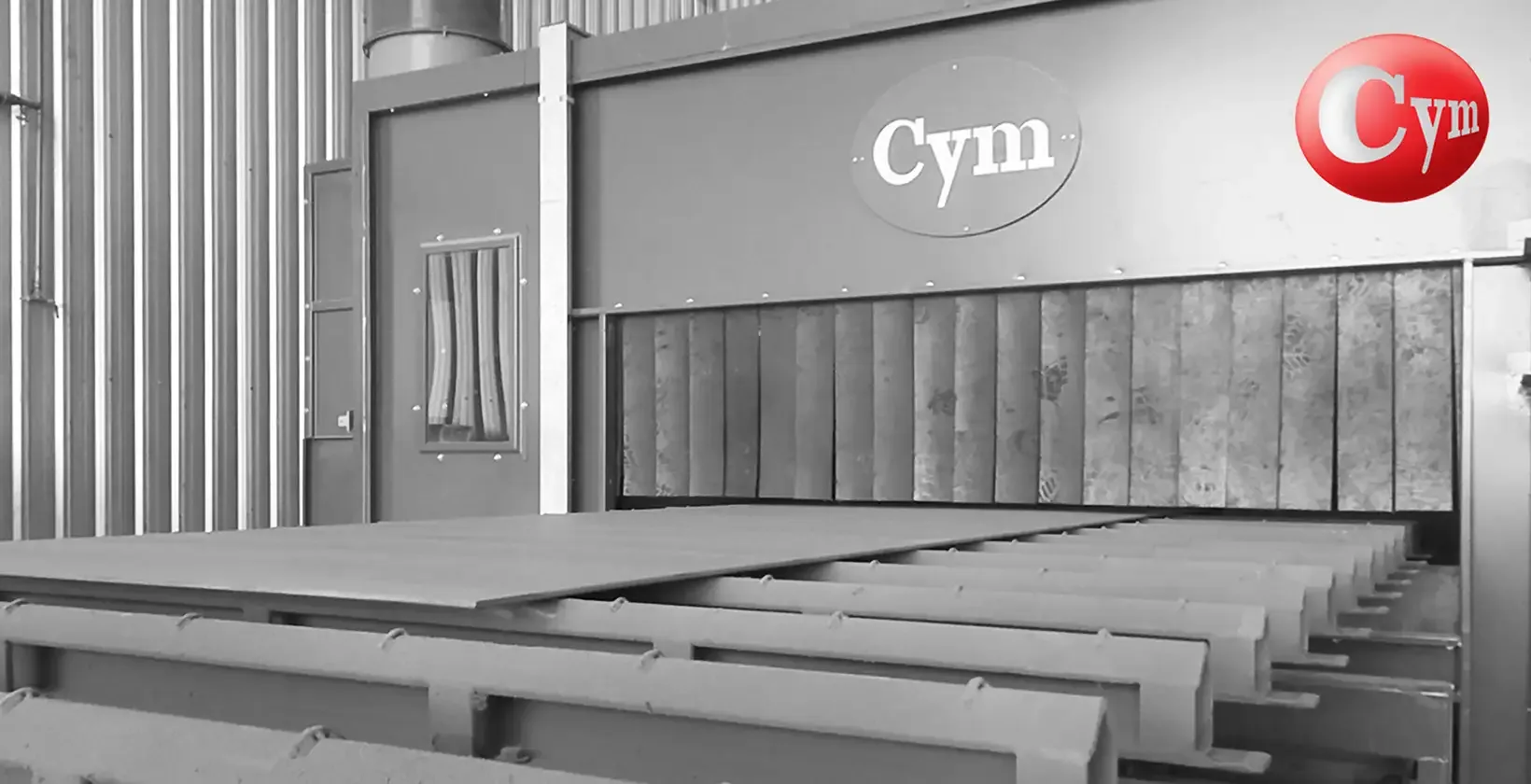 Saída do forno de secagem de shop primer na linha CYM CH 2.5H – chapas de aço com imprimação cinza no transportador de corrente · Astillero Paraná Sur, Argentina